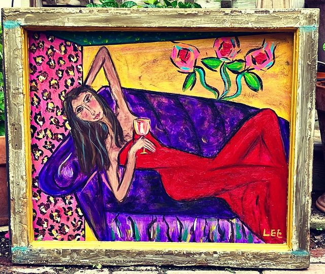 WOMAN ON PURPLE COUCH WITH FLOWERS